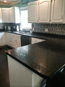 painted white cabinets with faux tin backsplash and black hd countertops