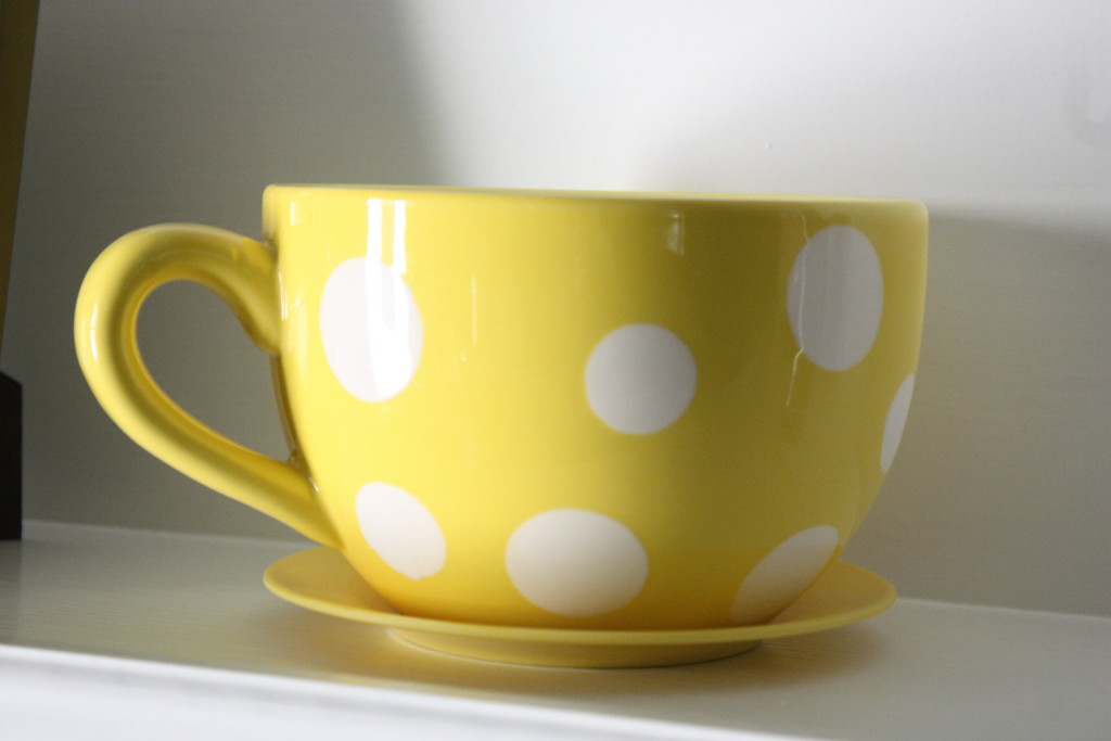 over sized yellow coffee cup with white polka dots