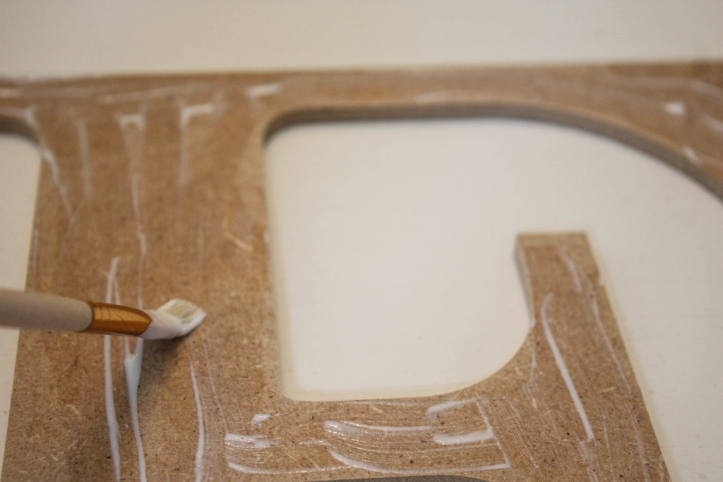 How to make a modge podge letter. Putting modge podge onto the wooden letter.