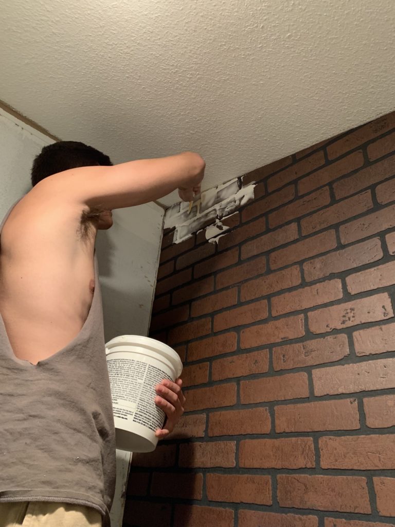 laundry room in a mobile home in process of installing brick board to german smear