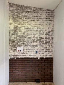 laundry room in a mobile home in process of installing brick board to german smear