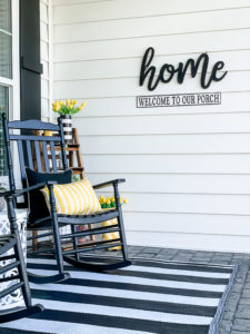 home sign on front porch with rocking chair