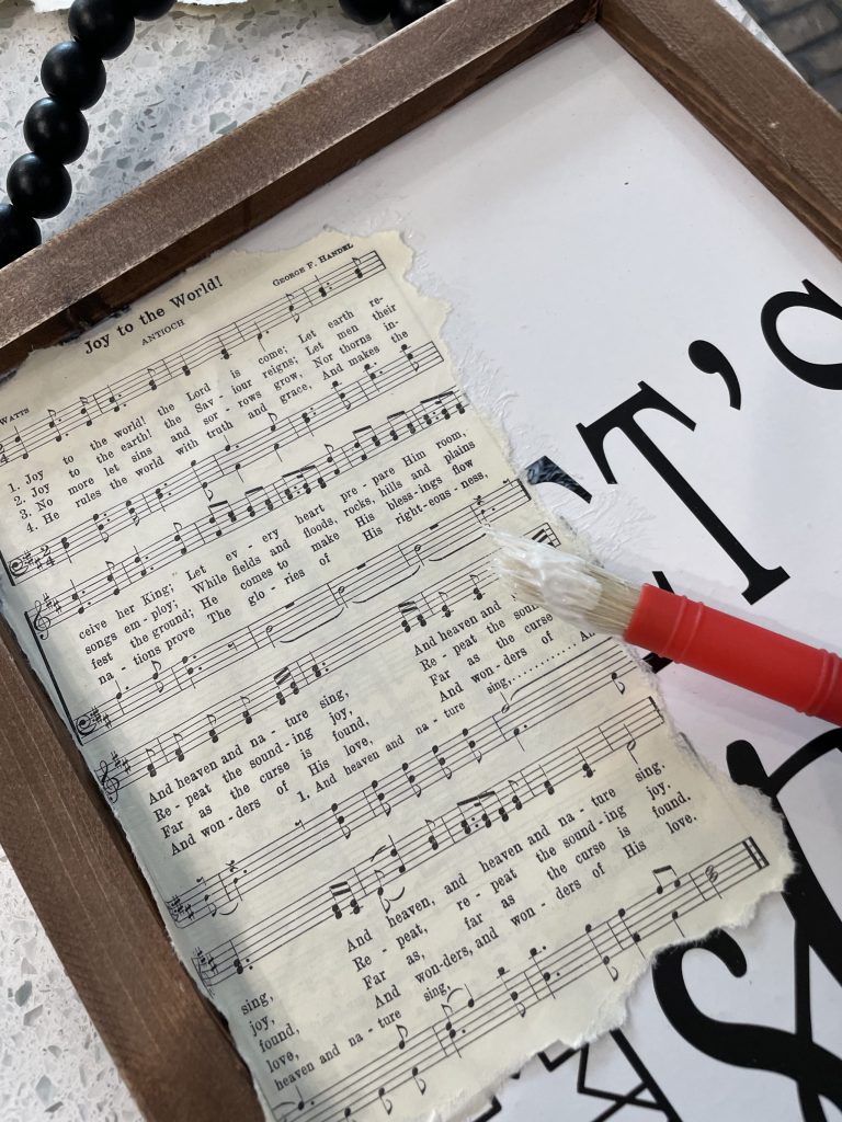 place and mod podge hymnal paper on sign