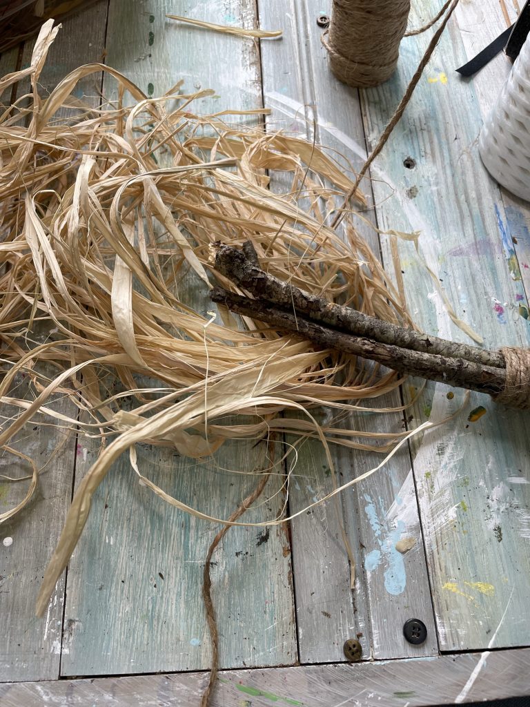 take the other side of the sticks, and wrap them with raffia to create the broom