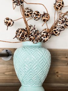 blue vase filled with leopard pumpkins