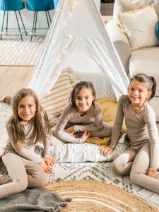 girls in their matching pajamas in the teepee