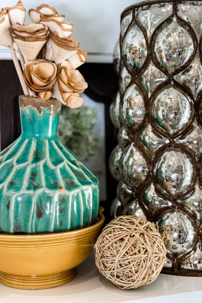 large metallic vase styled with aqua vase and wooden roses