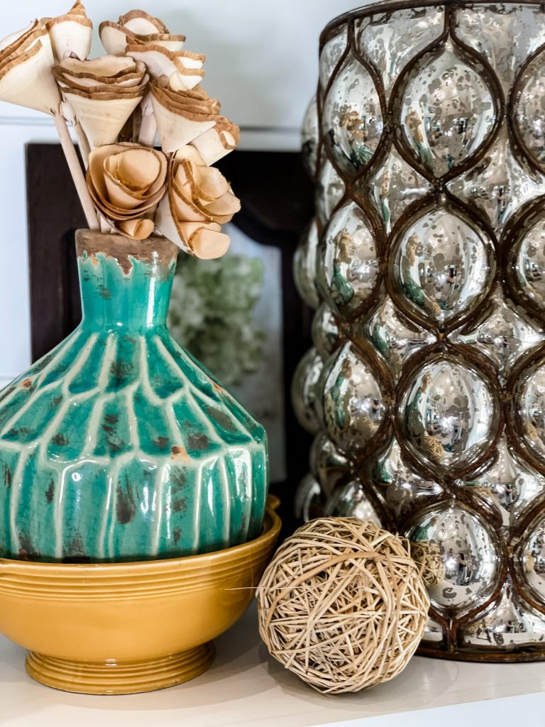 large metallic vase styled with aqua vase and wooden roses