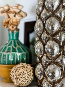 large metallic vase styled with aqua vase and wooden roses