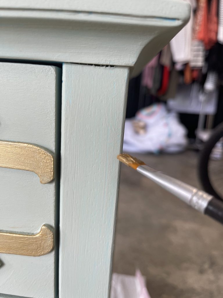 dry brush gold paint onto the edges of the side table