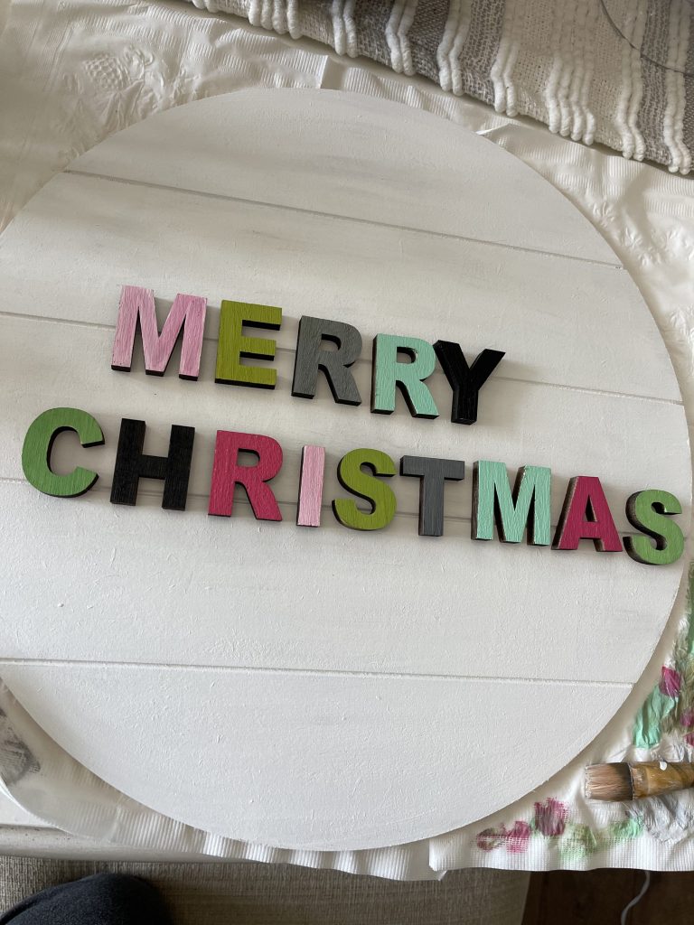colorful merry christmas letters placed onto wooden door hanger