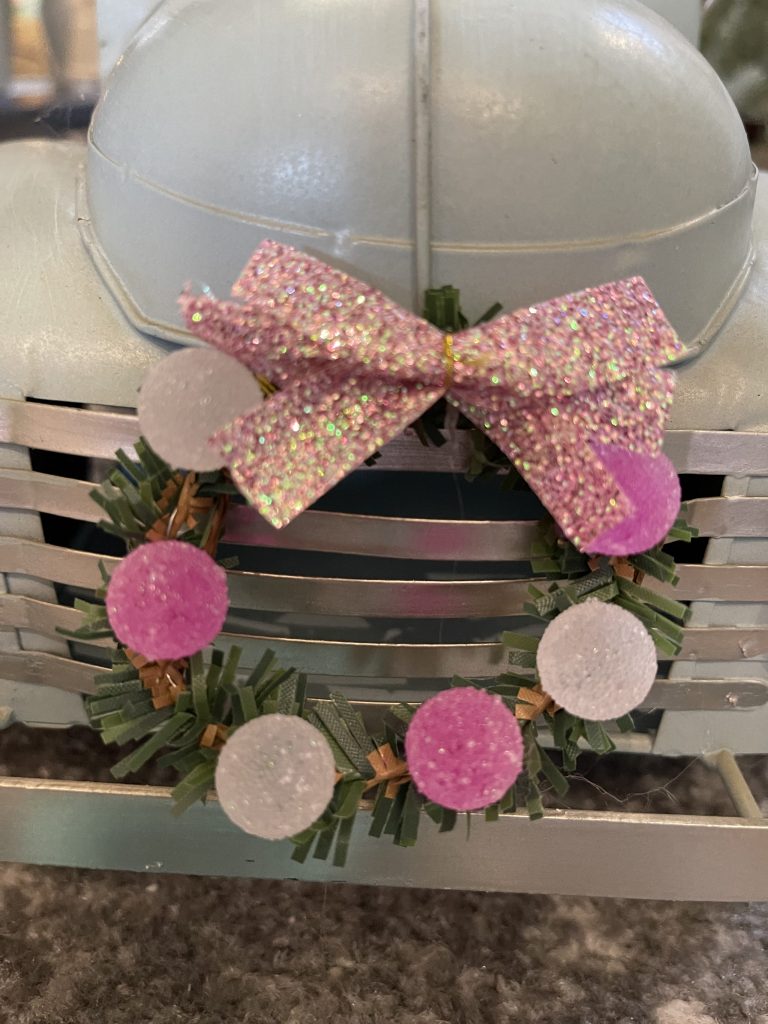 wreath with pink bow and mini candy ornaments on truck